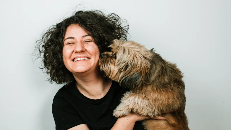 Perro dando un beso a una mujer